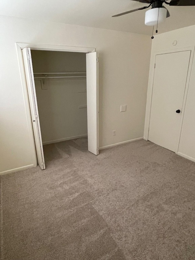 unfurnished bedroom featuring ceiling fan, a closet, carpet, and baseboards