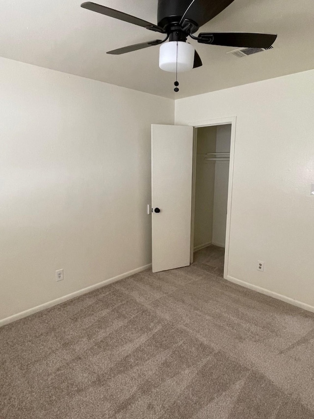 unfurnished bedroom with ceiling fan, carpet floors, a closet, and baseboards