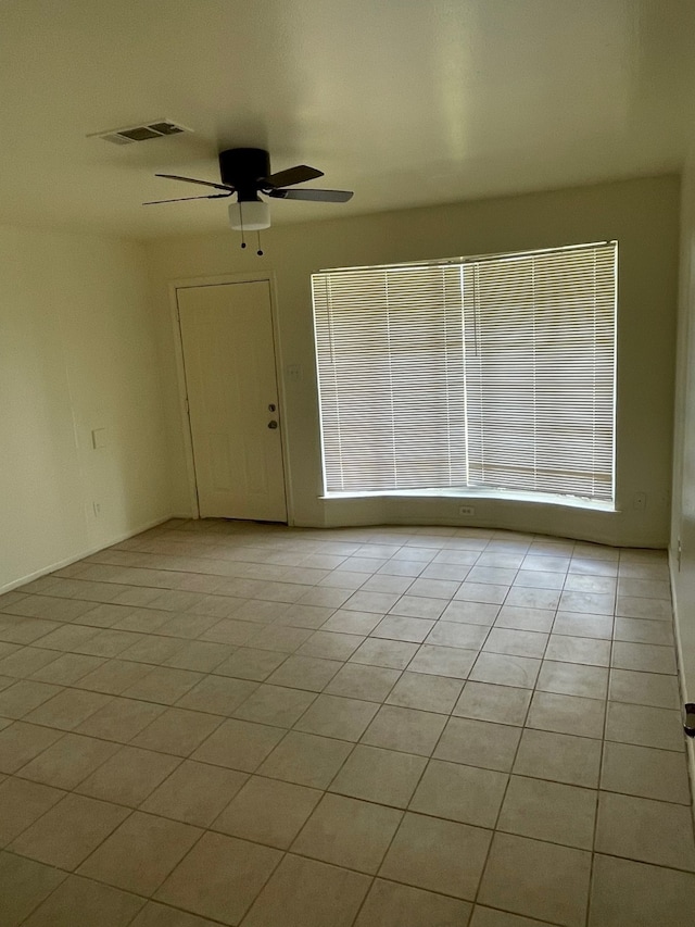 empty room featuring ceiling fan and light tile patterned flooring