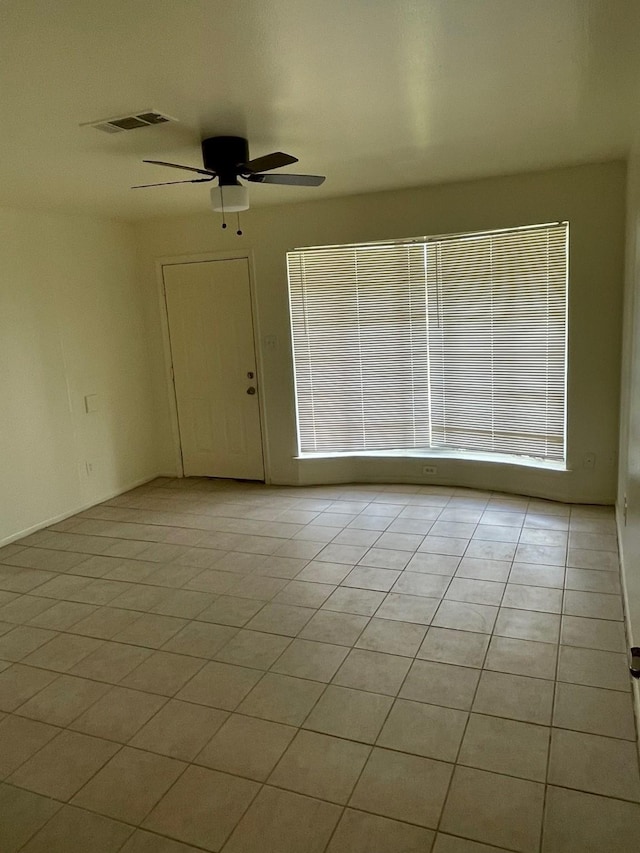 spare room with light tile patterned floors, ceiling fan, and visible vents