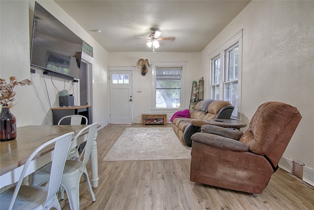 living room featuring light wood-type flooring and ceiling fan