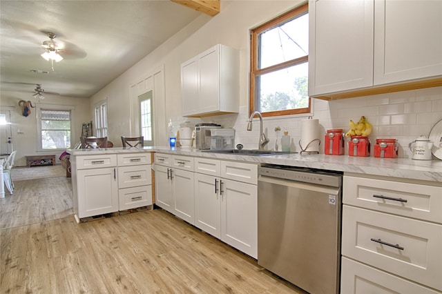 kitchen featuring stainless steel dishwasher, tasteful backsplash, sink, and light hardwood / wood-style floors