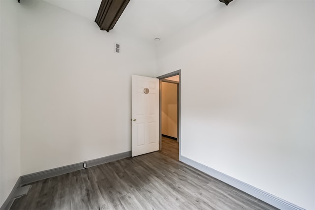 unfurnished room with dark wood-type flooring