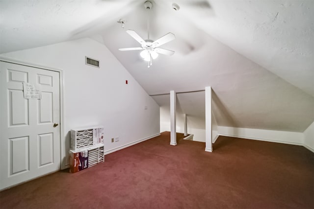 additional living space with lofted ceiling, dark colored carpet, and ceiling fan