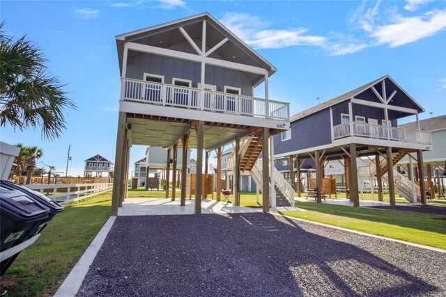 view of front of home featuring a front lawn, a carport, and a balcony