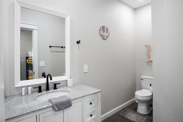 bathroom featuring vanity, hardwood / wood-style floors, and toilet