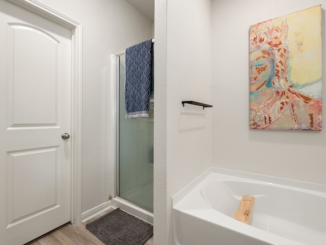 bathroom with shower with separate bathtub and hardwood / wood-style floors