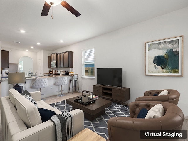 living room featuring ceiling fan and dark carpet