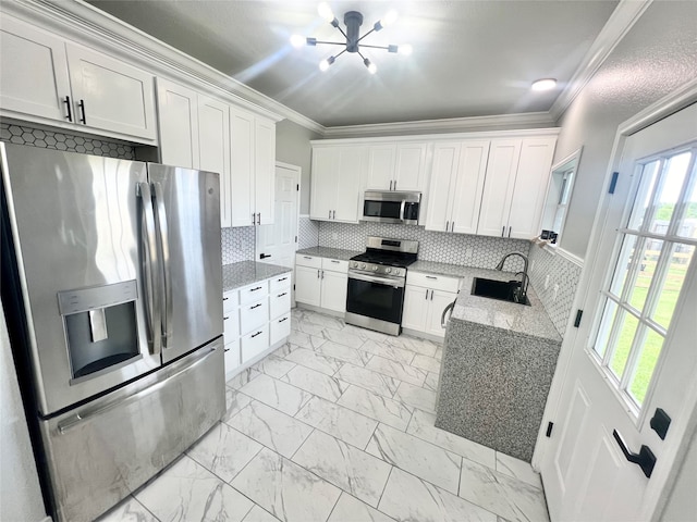 kitchen featuring crown molding, appliances with stainless steel finishes, sink, tasteful backsplash, and white cabinetry