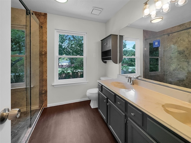 bathroom with hardwood / wood-style floors, toilet, an enclosed shower, and vanity