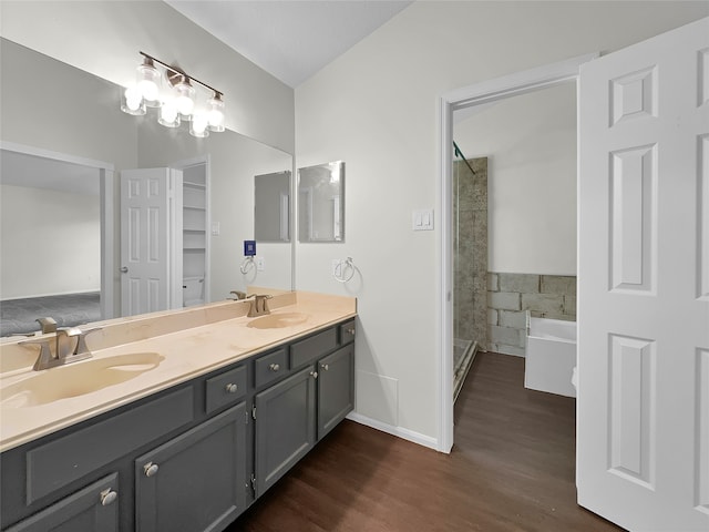 bathroom with wood-type flooring, dual vanity, and separate shower and tub