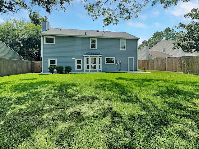 back of house with a lawn