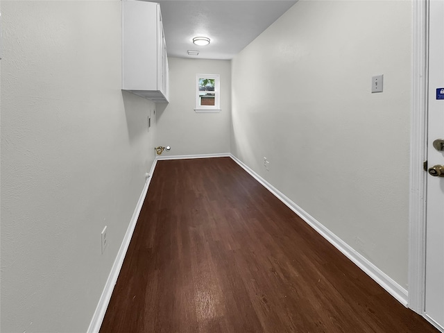 clothes washing area with dark wood-type flooring