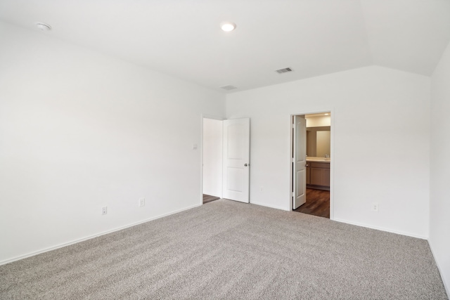 carpeted empty room with lofted ceiling