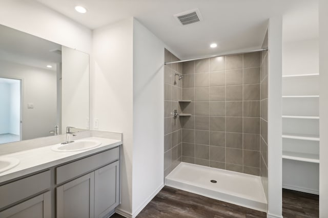 bathroom featuring a tile shower, vanity, and hardwood / wood-style flooring