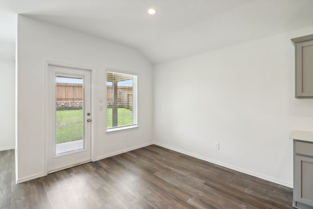 unfurnished dining area featuring lofted ceiling and dark wood-type flooring