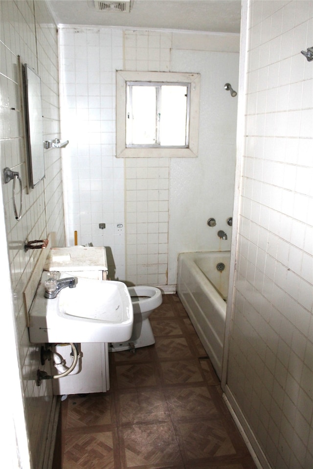 full bathroom with tub / shower combination, parquet floors, tile walls, and toilet