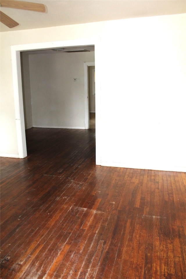 unfurnished room with ceiling fan and dark wood-type flooring