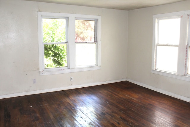 unfurnished room with a wealth of natural light and dark hardwood / wood-style floors