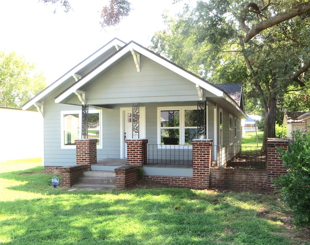 bungalow featuring a front lawn and covered porch