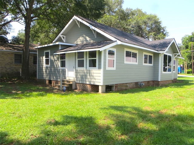 rear view of property featuring a yard