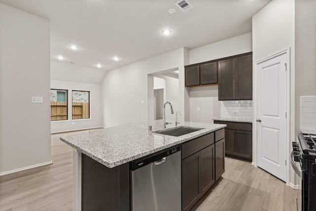 kitchen with light stone counters, tasteful backsplash, a kitchen island with sink, appliances with stainless steel finishes, and sink