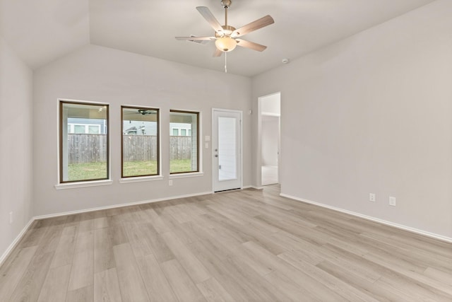 spare room featuring vaulted ceiling, light wood-type flooring, and ceiling fan