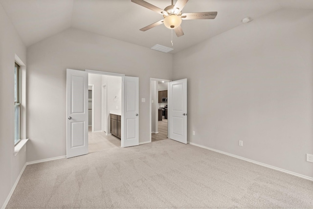 unfurnished bedroom featuring connected bathroom, ceiling fan, vaulted ceiling, and light colored carpet