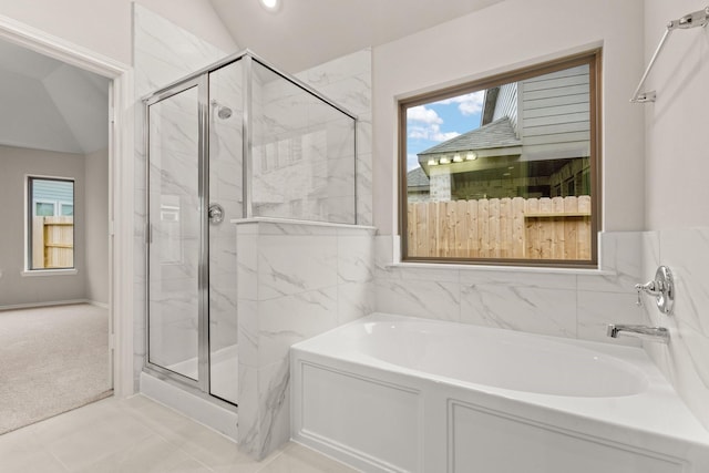 bathroom featuring independent shower and bath, tile patterned flooring, and lofted ceiling