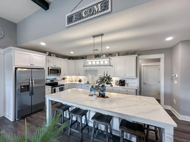 kitchen featuring white cabinetry, appliances with stainless steel finishes, decorative backsplash, and dark hardwood / wood-style flooring