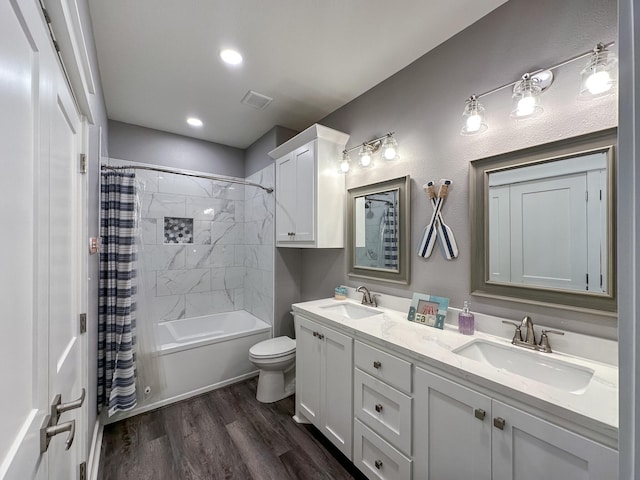 bathroom with a sink, toilet, wood finished floors, and double vanity