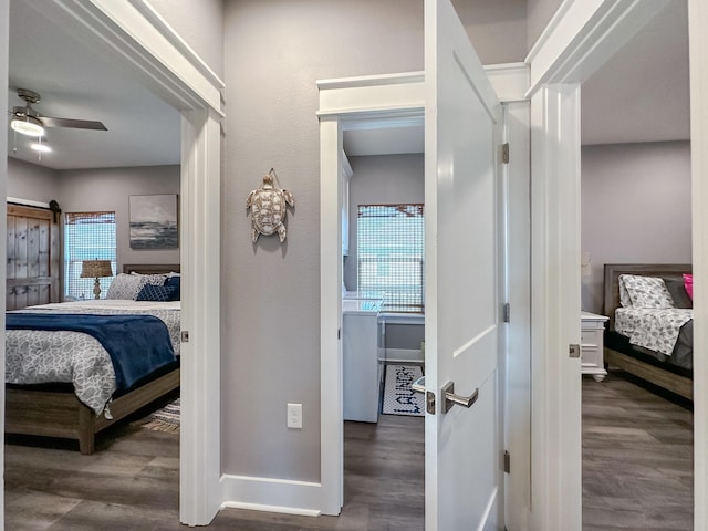 bedroom with a barn door, baseboards, and wood finished floors