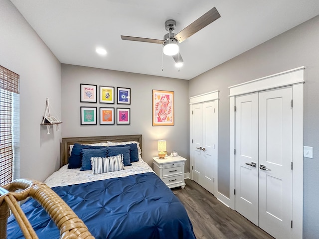 bedroom with dark wood-style flooring, two closets, and ceiling fan