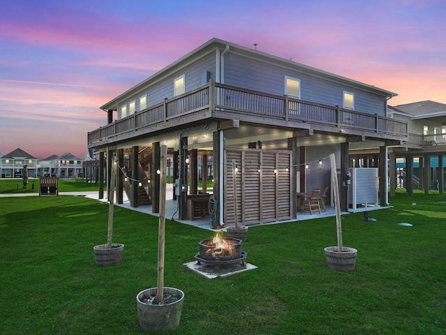 back house at dusk with an outdoor fire pit and a yard