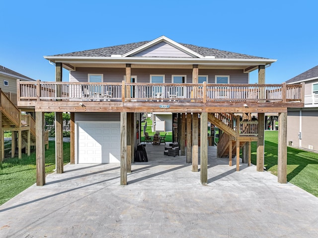 coastal inspired home featuring a front lawn, stairway, a carport, and a garage