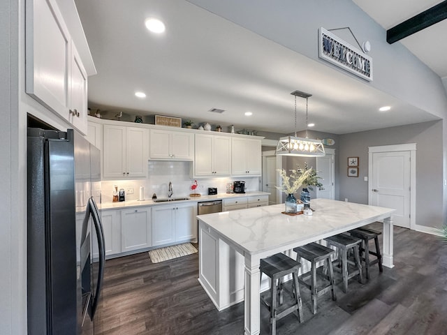 kitchen featuring a sink, stainless steel appliances, dark wood-type flooring, and white cabinets