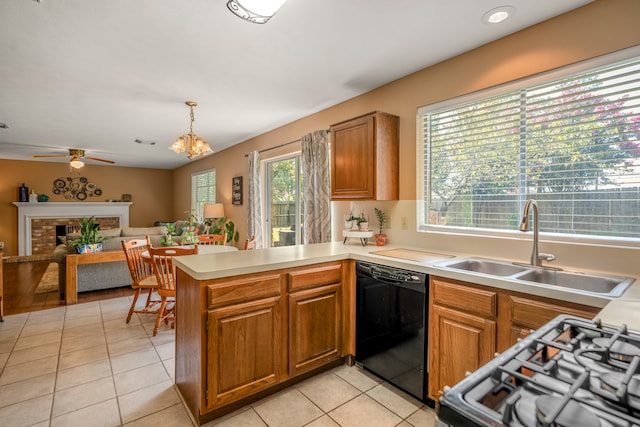 kitchen with dishwasher, kitchen peninsula, pendant lighting, a fireplace, and light tile patterned floors