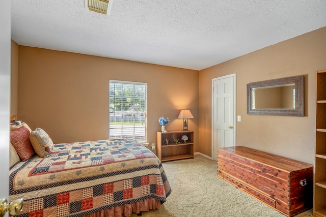 bedroom featuring light carpet and a textured ceiling