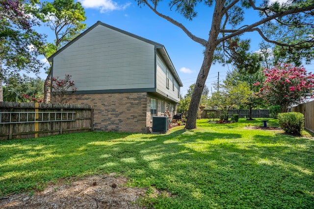 view of side of home with a yard and central air condition unit