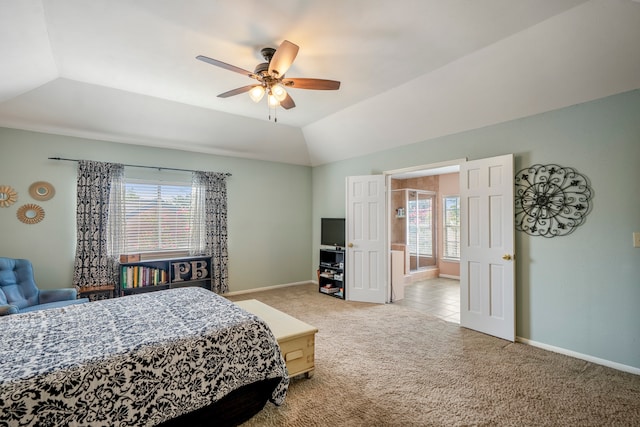 carpeted bedroom with a raised ceiling, ceiling fan, and lofted ceiling