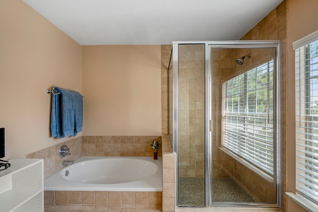 bathroom with shower with separate bathtub and a wealth of natural light