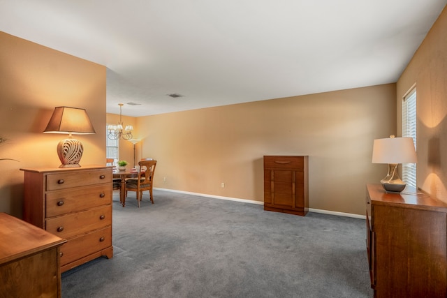 sitting room with dark colored carpet and a chandelier