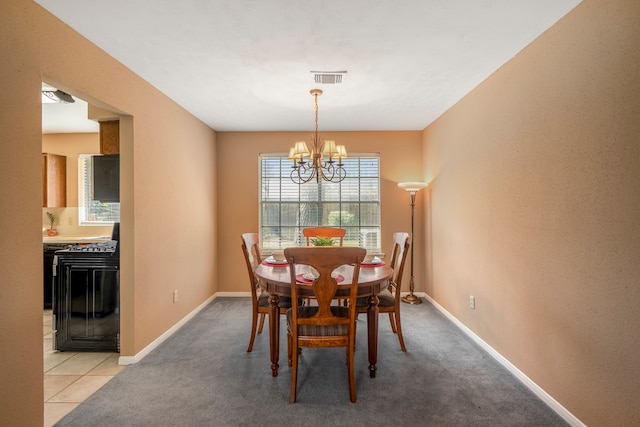 dining space with light colored carpet and a chandelier