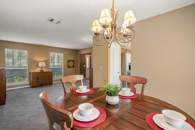 carpeted dining room with a chandelier