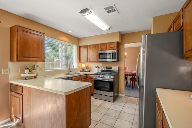 kitchen featuring sink, kitchen peninsula, stainless steel appliances, and light tile patterned floors