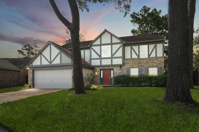 tudor-style house featuring a yard and a garage