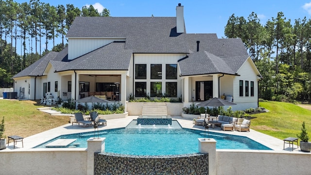 rear view of house featuring a patio, an outdoor living space, and a yard