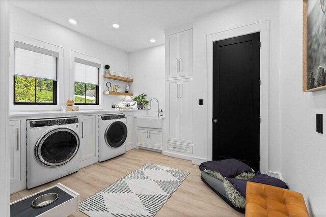 laundry room with cabinets, light hardwood / wood-style flooring, sink, and separate washer and dryer