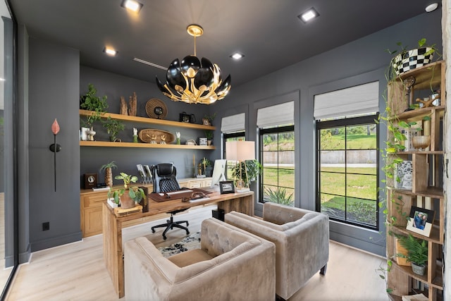 office space with light wood-type flooring and an inviting chandelier