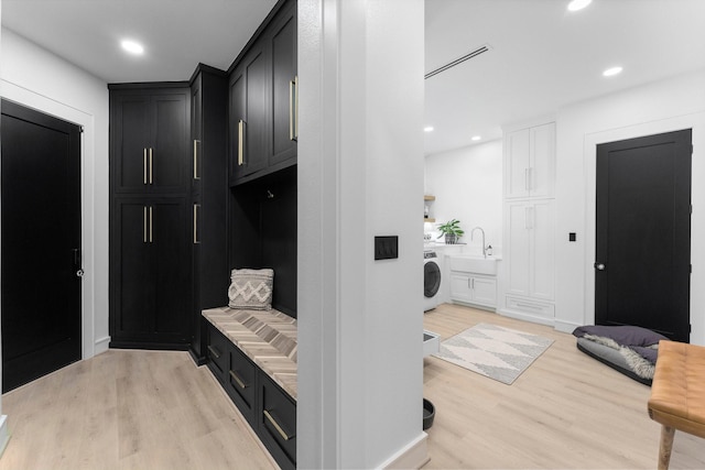 mudroom with washer / clothes dryer, sink, and light hardwood / wood-style floors